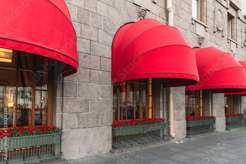 Photography Red awnings over the windows of the hotel
