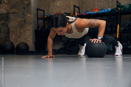 Purposeful female person training alone at the industrial place photo