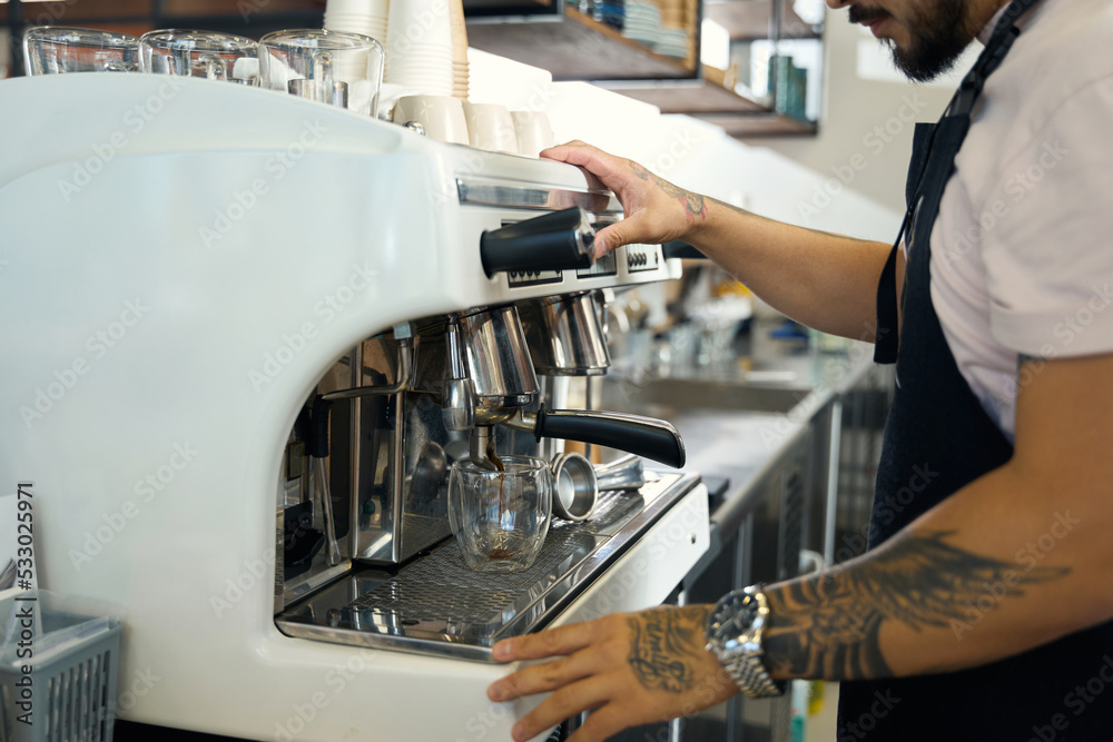 Young barista making an energizing shot of espresso at cafe Young barista making an energizing shot of espresso at cafe