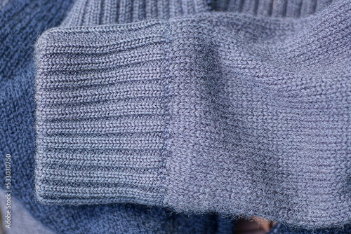 fabric texture from one gray woolen sleeve on a sweater