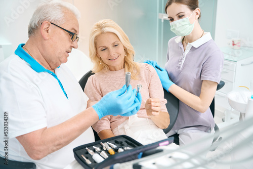 Female person and doctor discussing about surgery teeth