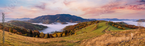 Morning foggy clouds in autumn mountain countryside.  Ukraine  Carpathian Mountains  Transcarpathia. Peaceful picturesque traveling  seasonal  nature and countryside beauty concept scene.