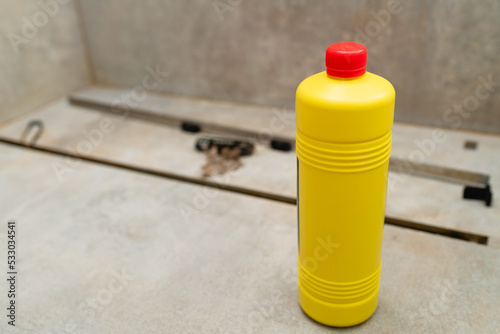 Liquid cleaner in a yellow bottle for cleaning sewer drains.