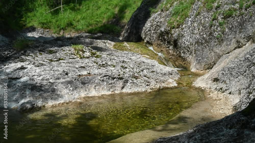Water from a rocky mountain river flowing over small cascades into a pool Water from a rocky mountain river flowing over small cascades into a pool
