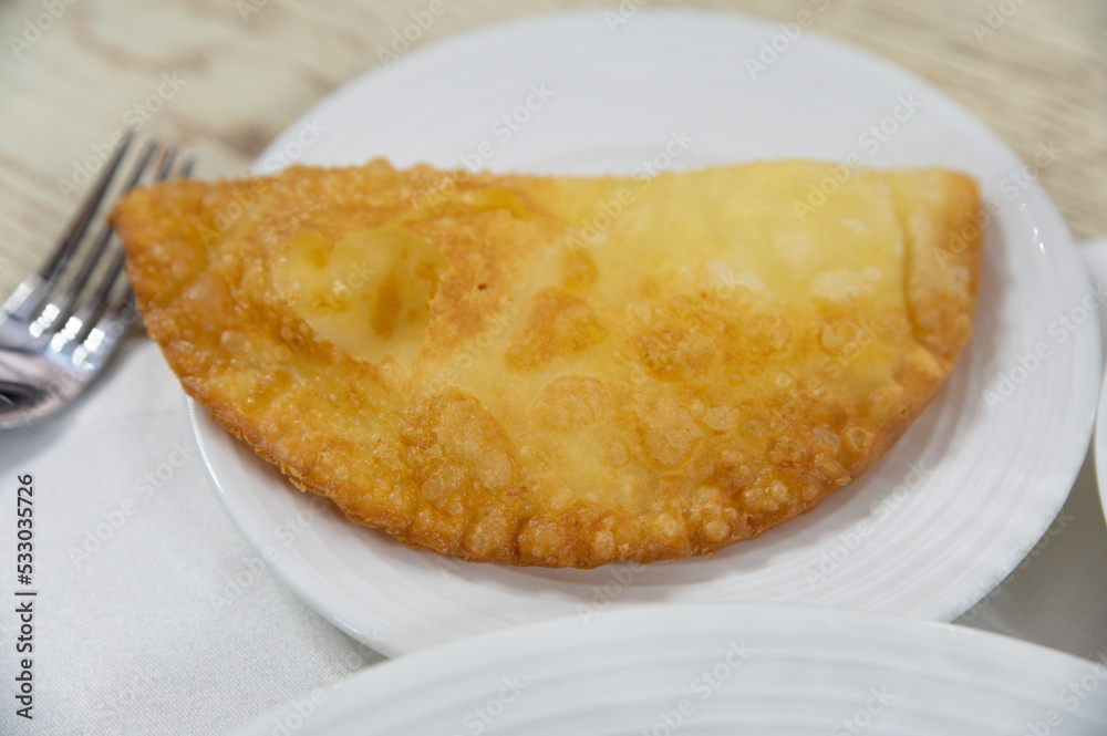 Chebureki or fried pie with meat on plate close up Chebureki or fried pie with meat on plate close up