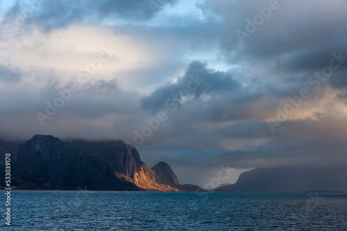 A patch of sunlight illuminates the coast of the island of Fugløya, Nordland, Norway