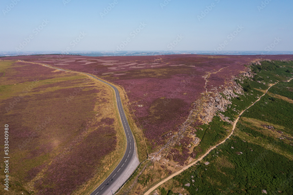 Stunning vibrant late Summer aerial drone landscape image of heather in full bloom in Peak District
