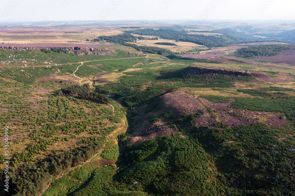 Stunning vibrant late Summer aerial drone landscape image of heather in full bloom in Peak District