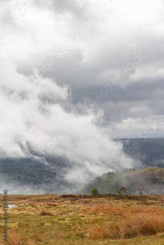 Dramatic Water vapour mist steam rising from hill and wood after rain storm.