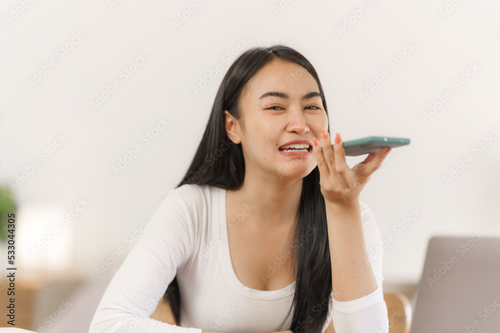 Attractive asian woman using personal smartphone voice calling app indoors. Attractive asian woman using personal smartphone voice calling app indoors.