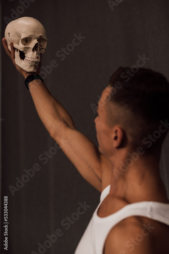 A white skull in the hands of a man. Anatomy