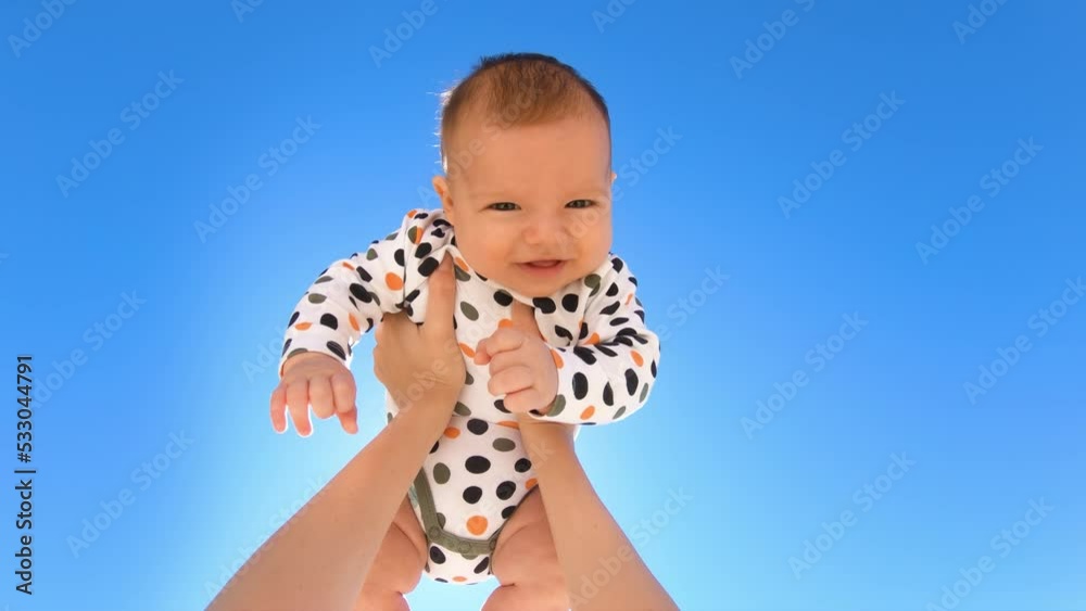 Mother throwing baby up against the blue sky. Happy woman enjoying motherhood with her little son outdoors. POV Mother throwing baby up against the blue sky. Happy woman enjoying motherhood with her little son outdoors. POV