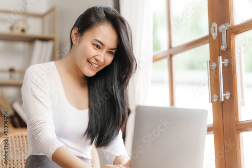 Happy smart asian woman freelancer working with laptop while live in the room.