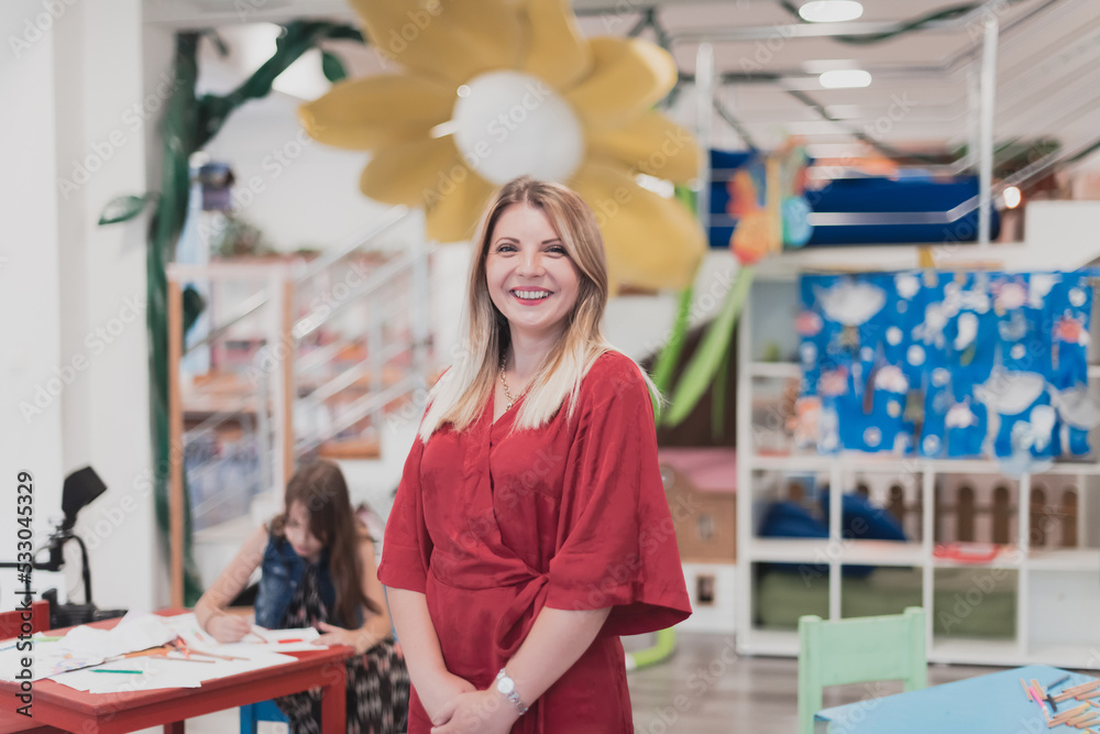 Portrait of a teacher in a preschool institution, in the background of the classrooms Portrait of a teacher in a preschool institution, in the background of the classrooms