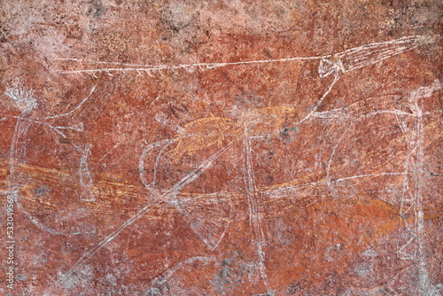 Aboriginal rock art: armed men with barbed spear-spear thrower-goosewing fan-headdress-arm ornament. Ubirr-Kakadu-Australia-197