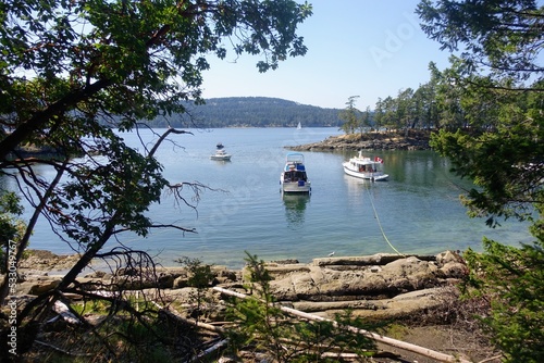 Fotografiet Boats anchored in a small cove using their stern line to secure anchorage, in Co