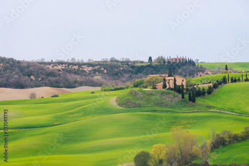 View of a farm upon the green hills of the Tuscany countryside   Italy