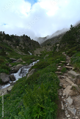 Wild Landcape in Andorra during spring season : water spring flowing down the mountains during foggy morning