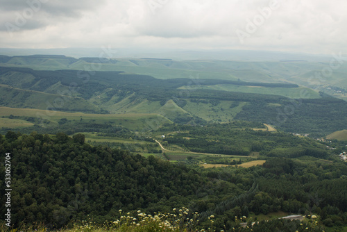 Panoramic top view of a beautiful valley with trees and hills and a blurred horizon against a cloudy dramatic sky in Kislovodsk russia