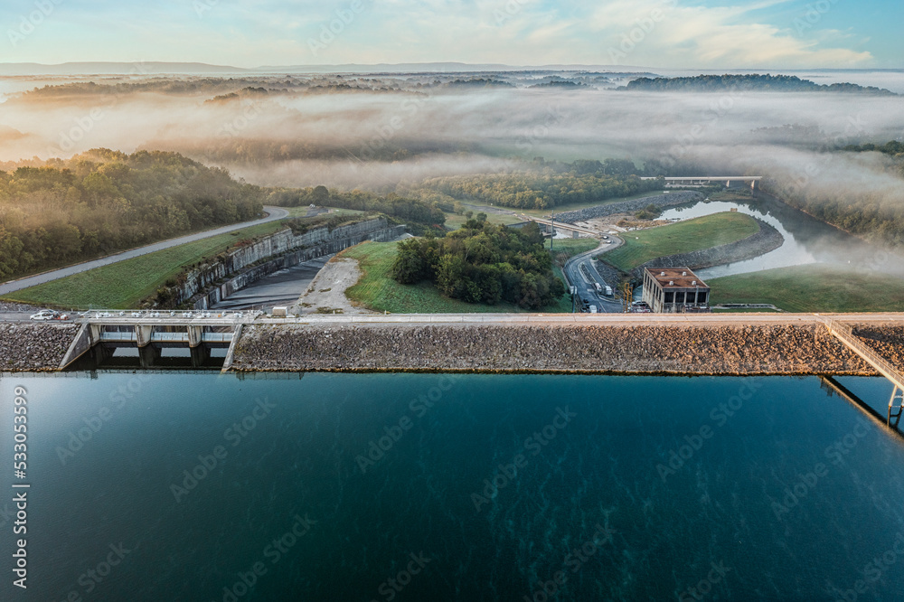 Aerial view of a dam, power station with a foggy sunrise on Tims Ford Lake in Tennessee