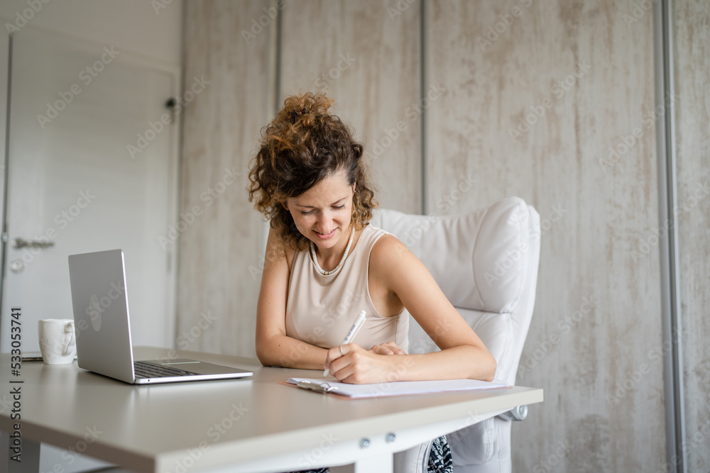 One young business woman back to work in the office working on laptop One young business woman back to work in the office working on laptop
