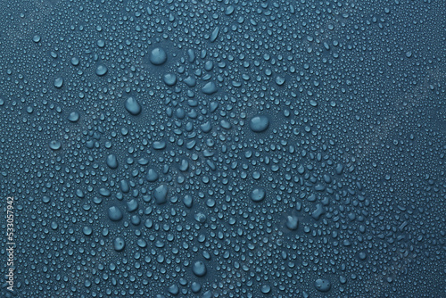 Many water drops on dark dusty blue background