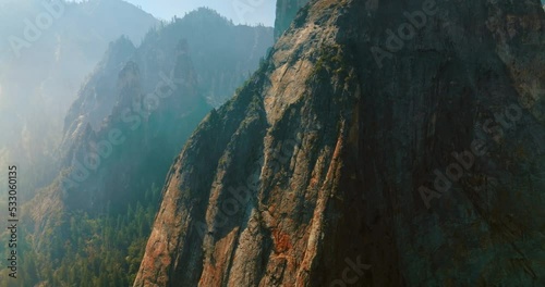 Sharp steep cliffs covered with thick white fog in Yosemite National Park, California, USA. Drone footage among the powerful rocks. photo