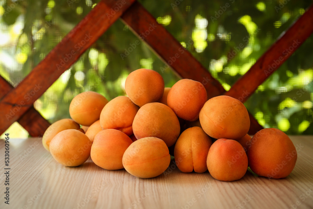 Heap of delicious ripe apricots on wooden table outdoors Heap of delicious ripe apricots on wooden table outdoors