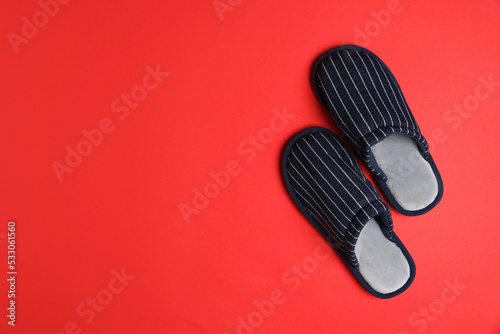 Pair of stylish slippers on red background, top view. Space for text
