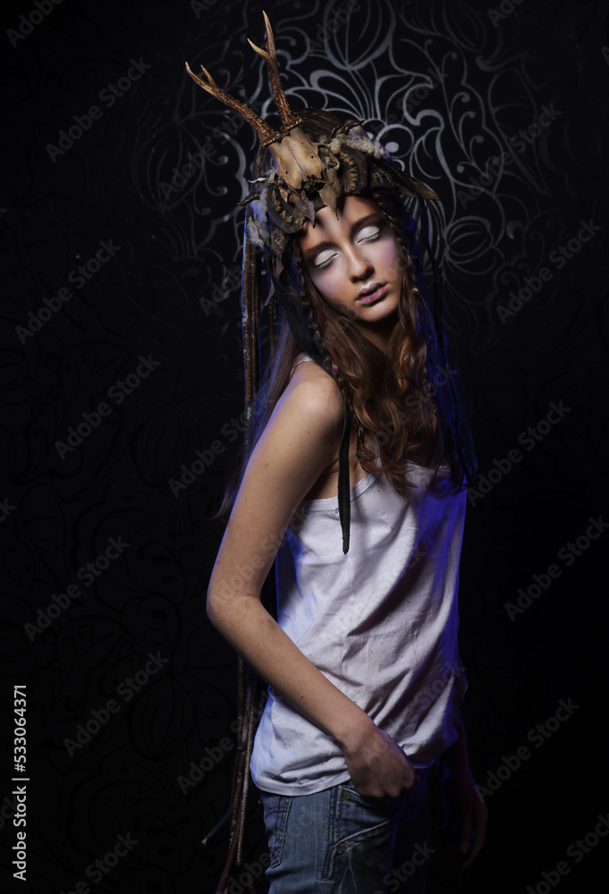 Young female model with bright makeup, braids and a skull on her head Young female model with bright makeup, braids and a skull on her head
