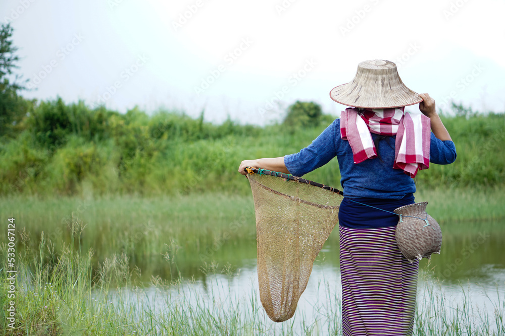 Back view of Asian woman farmer wears hat and traditional costume