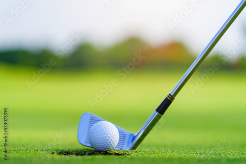 Golf ball and golf club in beautiful golf course at Thailand. golf equipment resting on green grass background