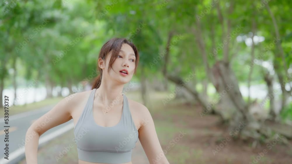 Asian woman is engaged in fitness and stretching in public park. Sporty woman does exercises in the open air. Healthy lifestyle, sports outdoor activities in park Asian woman is engaged in fitness and stretching in public park. Sporty woman does exercises in the open air. Healthy lifestyle, sports outdoor activities in park