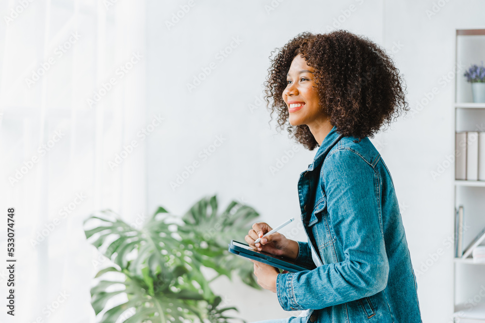 Young pretty african american freelancer working at office workplace, using computer tablet pc. Young pretty african american freelancer working at office workplace, using computer tablet pc.