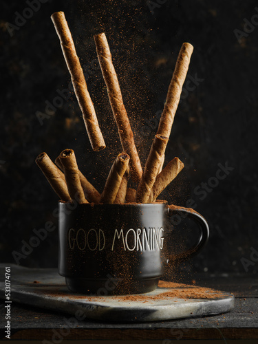 Lots of fragrant cinnamon sticks in a cup on a black background. Aromatic additive, spice for coffee, tea, cocktail, alcoholic beverages. Symbol of the holiday, Christmas.