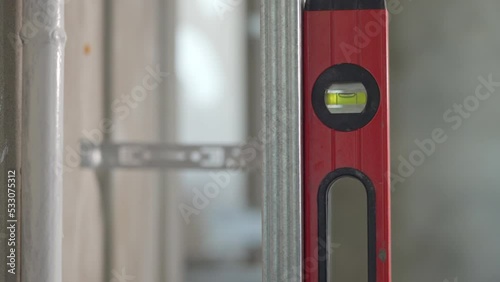 A worker checks the vertical plane with a construction level