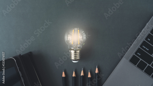 Bright lightbulb with laptop, book or textbook and pencil. Growth idea of business working and education learning success. Businessperson and student skill training and knowledge development