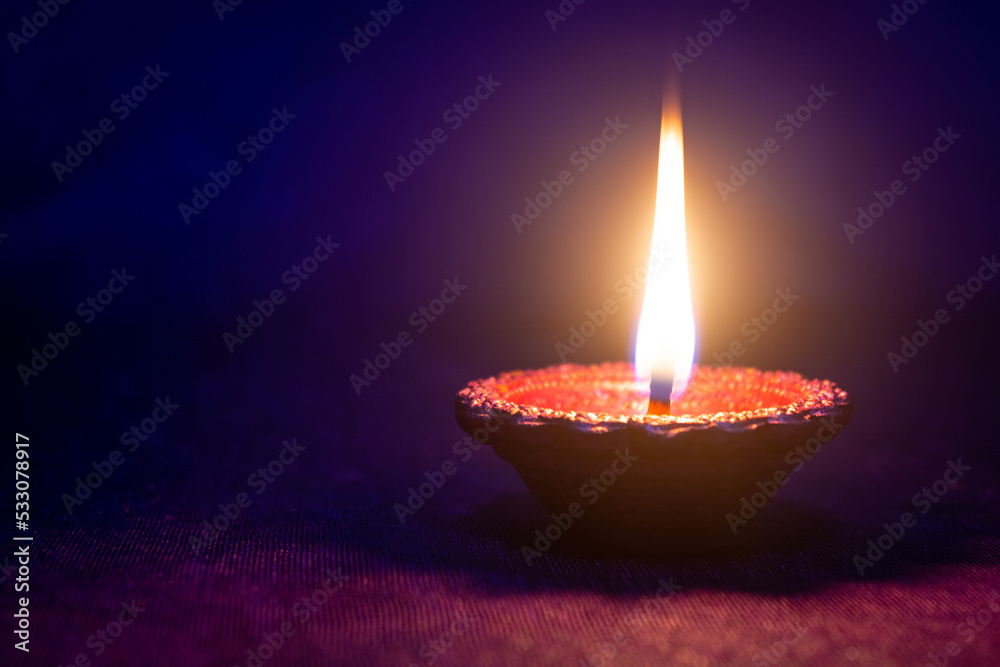 Happy Diwali - Clay diya lamp lit during diwali celebration Happy Diwali - Clay diya lamp lit during diwali celebration