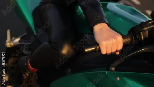 Crop anonymous woman starting motorbike in sunlight