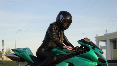 Crop anonymous woman starting motorbike in sunlight