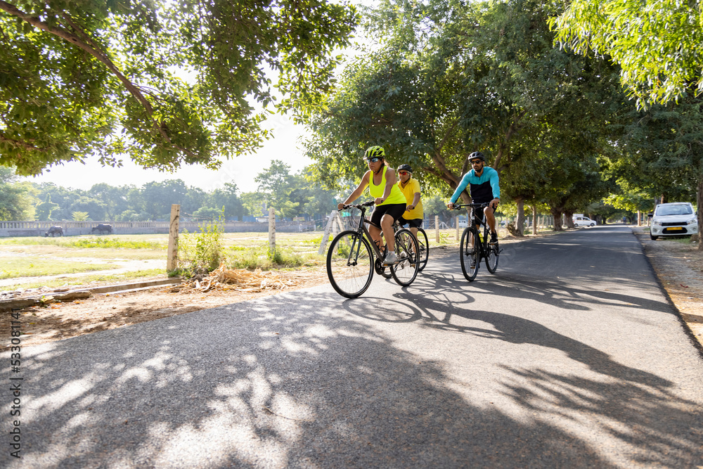 Naklejka premium Confident cyclists riding bicycle on countryside road