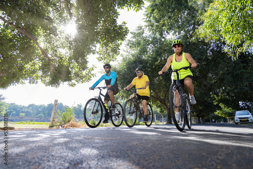 Confident cyclists riding bicycle on countryside road 