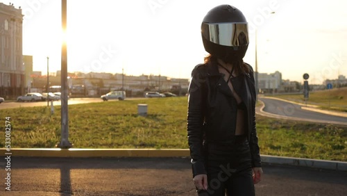 Anonymous cool woman sitting on motorbike on city street