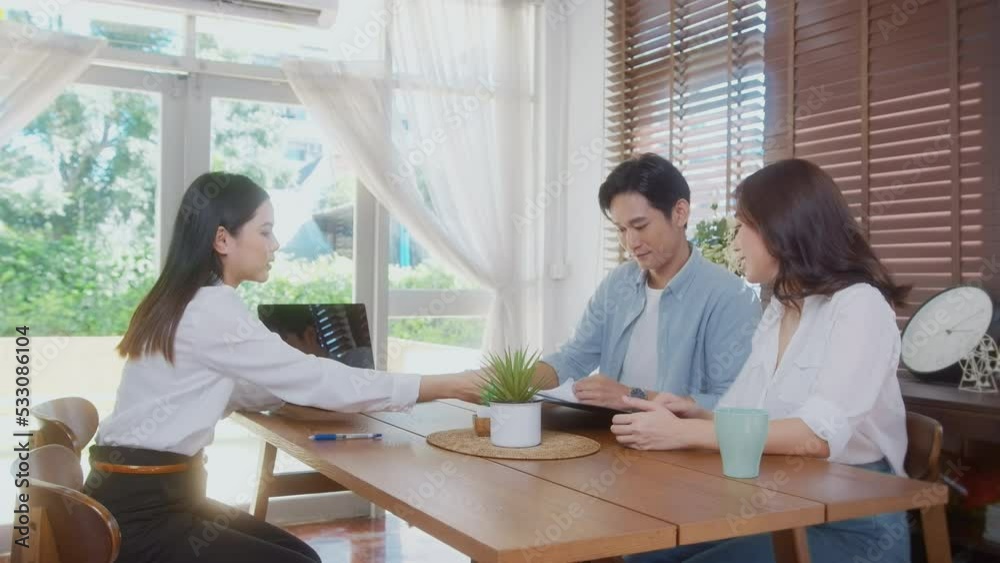 Young married couple meeting with female real estate agent or insurance consultant offering promotions , Mortgage, loan, property and medical health insurance concept. Young married couple meeting with female real estate agent or insurance consultant offering promotions , Mortgage, loan, property and medical health insurance concept.