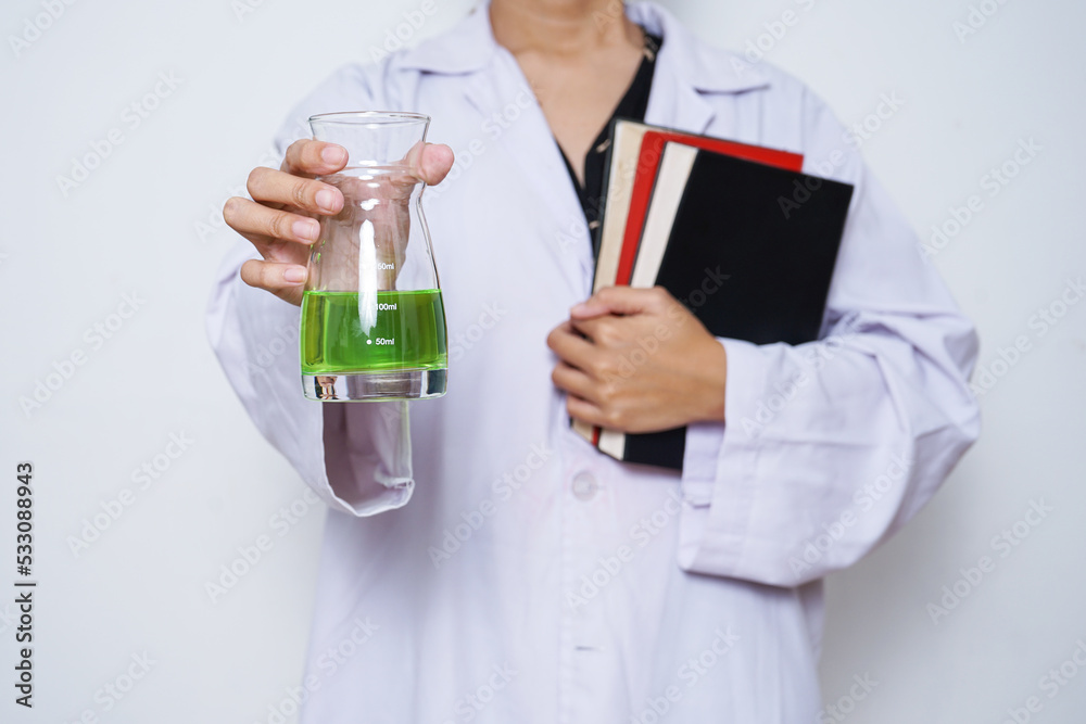 Close-up of scientist hands in a white lab coat holding chemical glassware and books. against white background. Knowledge, learning, study concept. Close-up of scientist hands in a white lab coat holding chemical glassware and books. against white background. Knowledge, learning, study concept.