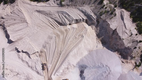 Aerial top down view of a mining crawler bulldozer in limestone quarry.