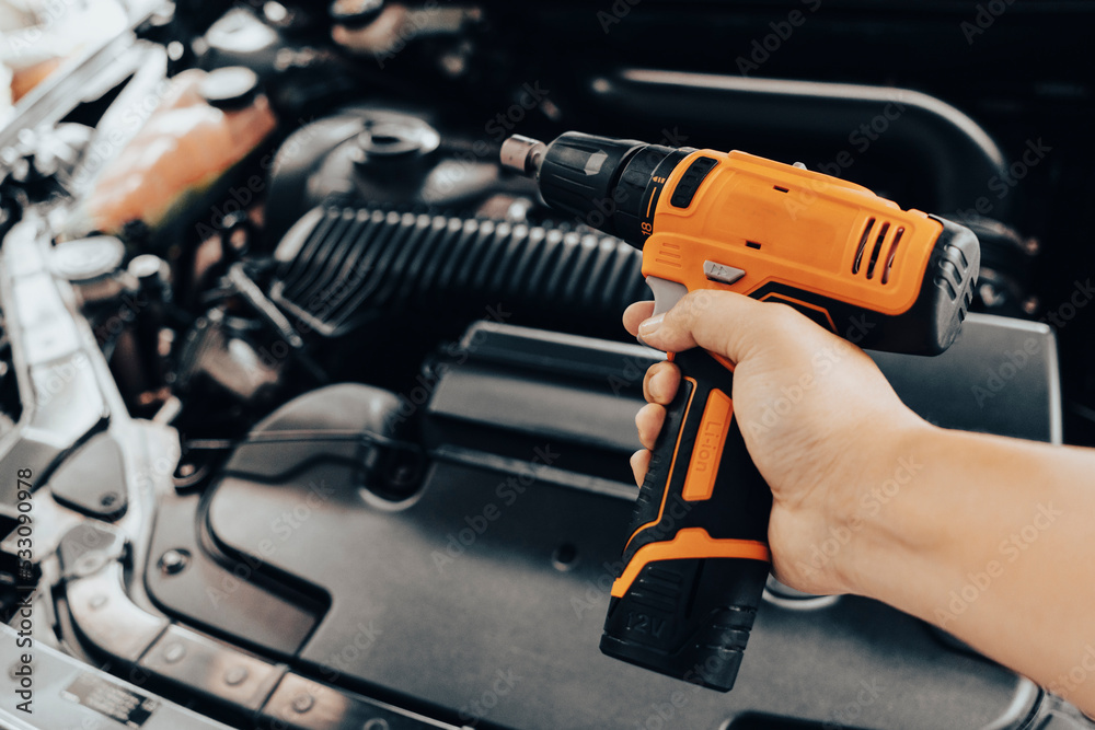 Automobile mechanic repairman hands repairing a car engine automotive workshop Automobile mechanic repairman hands repairing a car engine automotive workshop