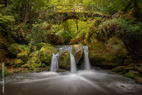 Wasserfall mit Br  cke im Wald