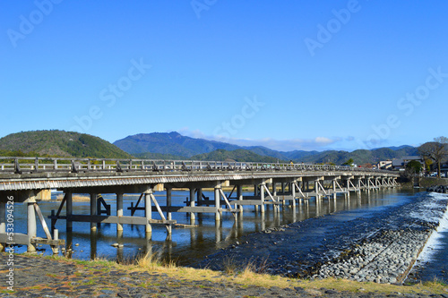 春に歩く京都市嵐山中之島から望む渡月橋と愛宕山 photo