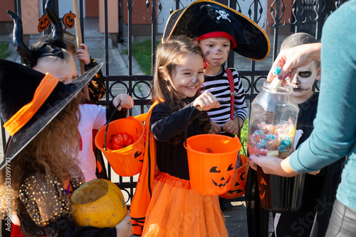 Woman giving treats to children in costumes